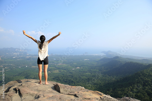 cheering young woman hiker open arms outdoor
