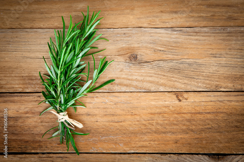 Rosemary bound on a wooden background.