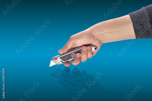 man's hand holding a knife stationery