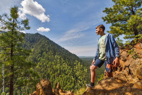 Teenager at the top of a hill in Siberian forest