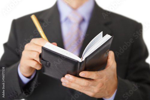 Businessman takes notes in notebook - closeup