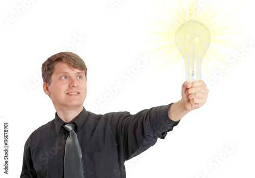 Young man lit by bright idea in form of electric light