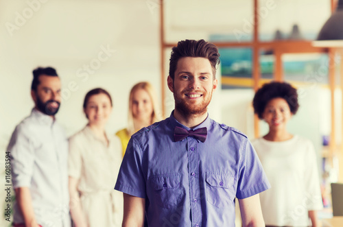 happy young man over creative team in office
