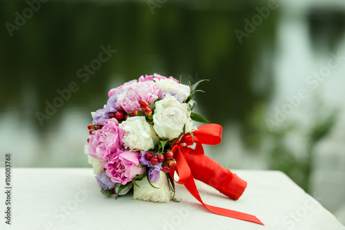 свадебный букет из пионов с красной лентой для невесты  