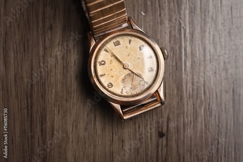 Vintage wristwatch on a wooden table. Classic men's watch