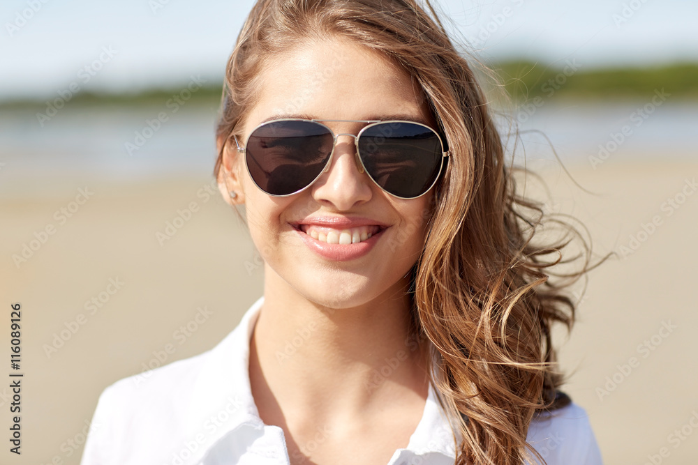 smiling young woman in sunglasses on beach smiling young woman in sunglasses on beach