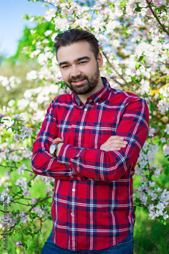portrait of young farmer in blooming garden