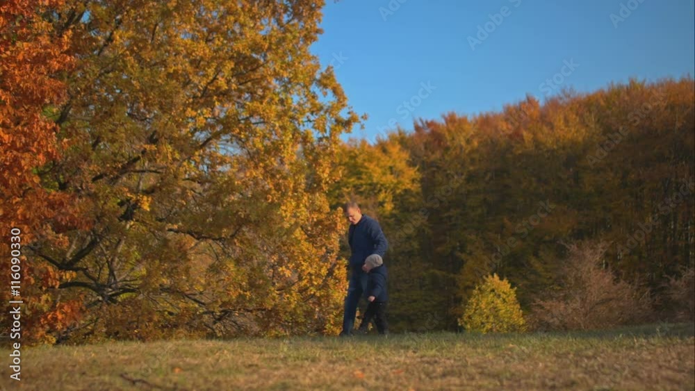 Son and dad walking in the autumn forest. Son and dad walking in the autumn forest.