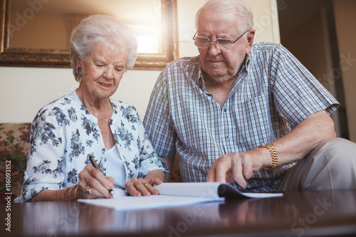 Senior couple doing retirement paperwork photo