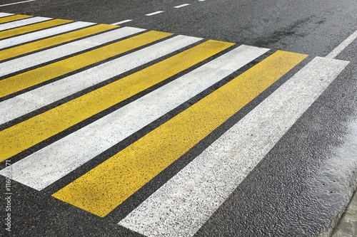 White Yellow Zebra Pedestrian Crossing On The Wet Asphalt Road