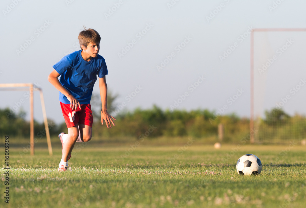 Naklejka premium Boy playing football