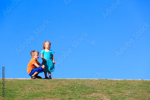 little boy and girl looking up at blue sky