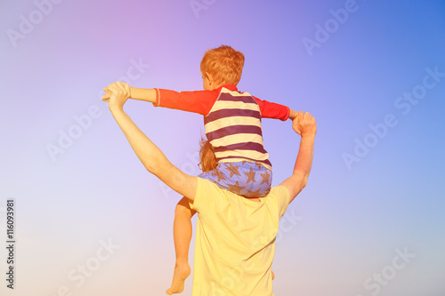 happy father and son playing on sky