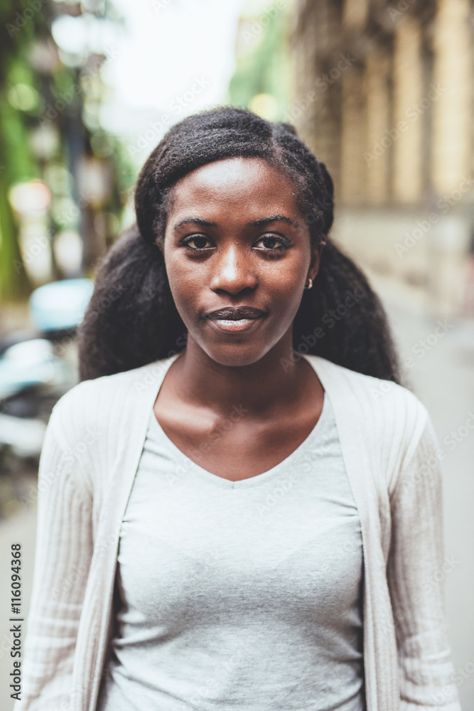 Half length of young beautiful black woman outdoor in the city, looking at camera, smiling - happiness, carefree, thoughtless concept Half length of young beautiful black woman outdoor in the city, looking at camera, smiling - happiness, carefree, thoughtless concept