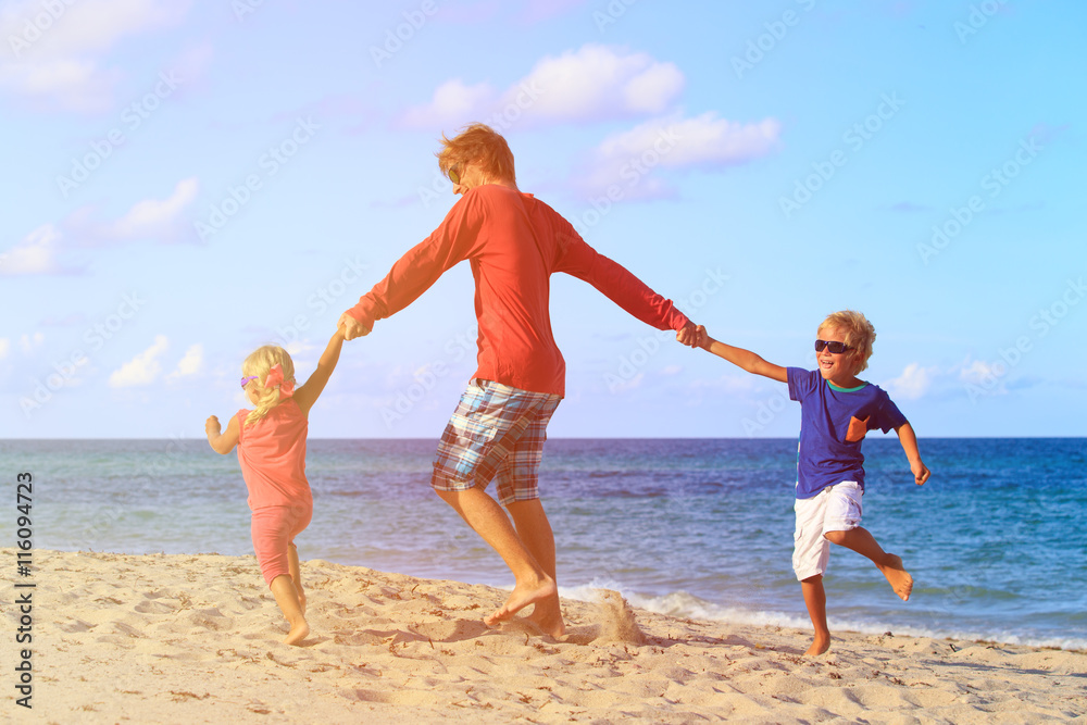 father with son and daughter play at beach