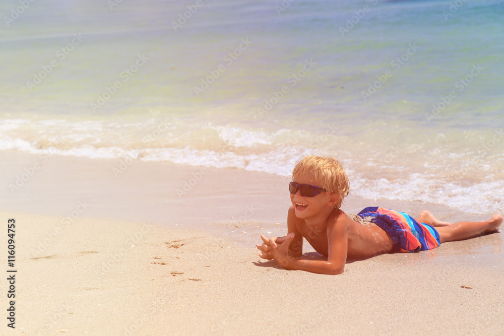 happy little boy relaxed on beach