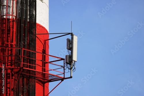 Red and white tube boiler with cables of telecommunications equipment, primarily for cellular transmission photo