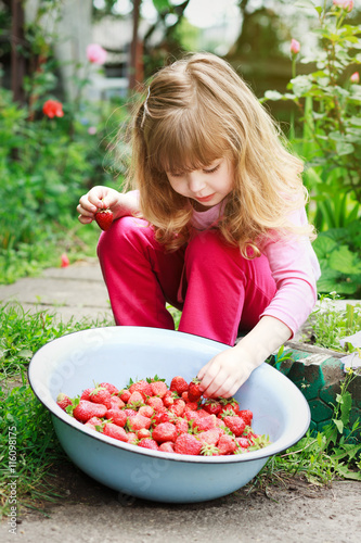 Smiling Girl Holding Bowl of Strawberries