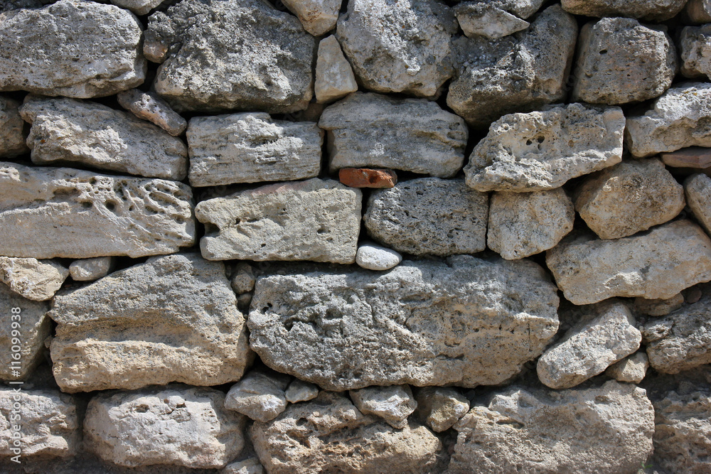texture of old dilapidated shabby sandstone masonry of wild natural sandstone stones wall foreground closeup in Crimea