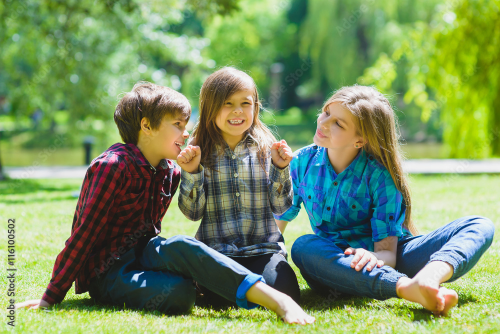 Smiling kids having fun at grass. Children playing outdoors in summer. teenagers communicate outdoor