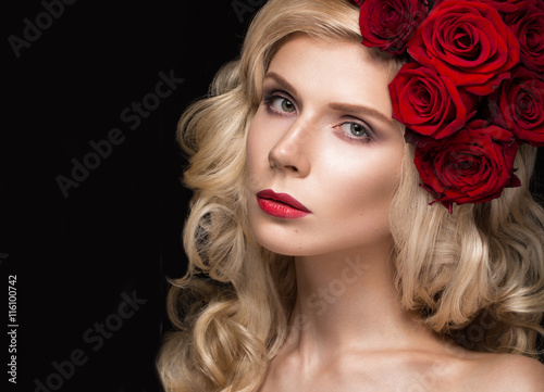 Beautiful blond girl in dress and hat with roses, classic makeup, curls, red lips. Beauty face.