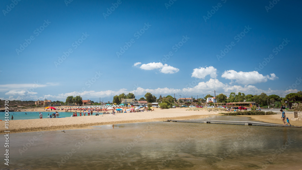 Stavros beach on Crete island, Greece. Tourists relax and bath in crystal clear water. Stavros beach on Crete island, Greece. Tourists relax and bath in crystal clear water.