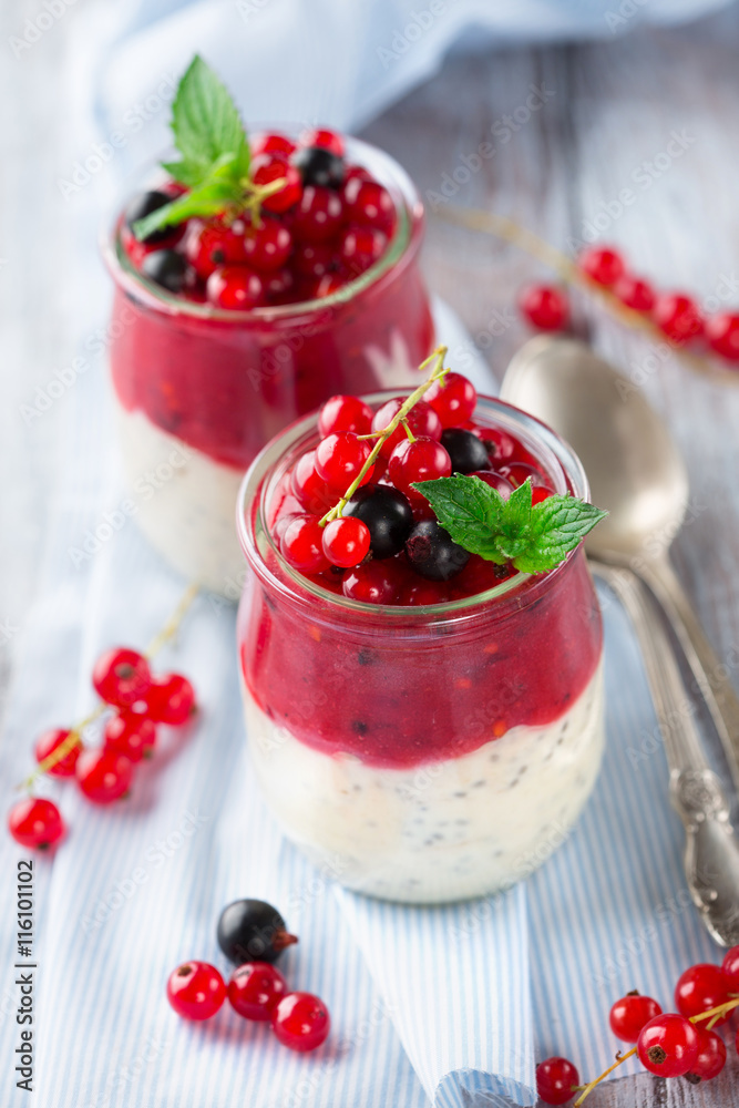 Layered berry and chia seeds smoothies in jar for breakfast on white rustic wooden background, selective focus Layered berry and chia seeds smoothies in jar for breakfast on white rustic wooden background, selective focus