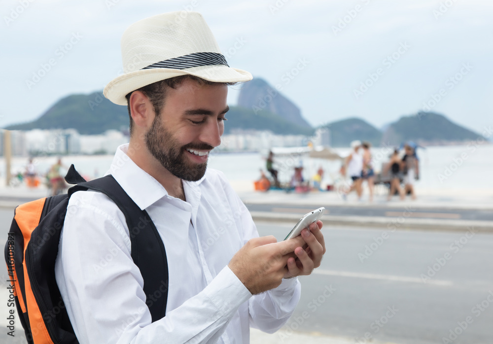 Laughing tourist looking for the right way at phone