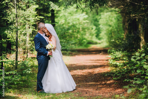 newlyweds in park.newlyweds on walk in the beautiful wood.newlyweds embrace.embraces of newlyweds.newlyweds in the spring wood.gentle.relations.feelings.beautiful groom and bride. Bride with ore hair