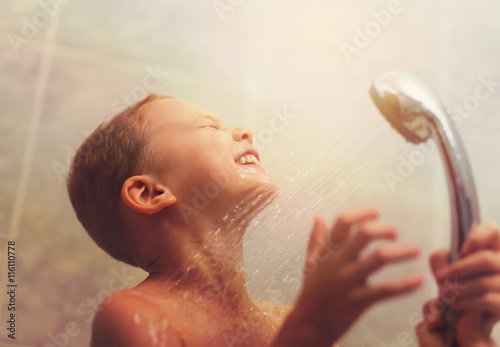 Portrait of cute boy having shower with eyes closed