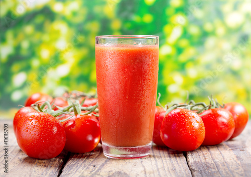 glass of tomato juice on wooden table
