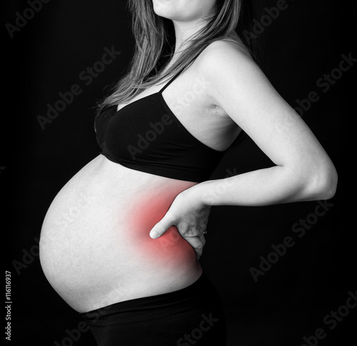 Belly of a pregnant woman with Lower back pain. photo