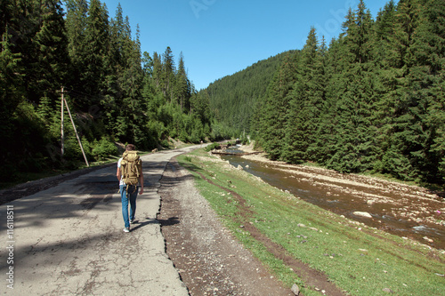 Adventure man hiking wilderness mountain with backpack, outdoor lifestyle survival vacation