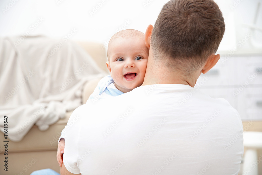 Happy father holding sweet baby in the room Happy father holding sweet baby in the room