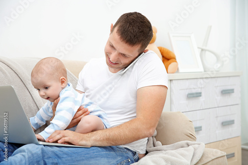 Father working on laptop an...