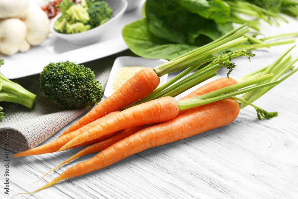 Carrots with vegetables and spices on wooden table Carrots with vegetables and spices on wooden table