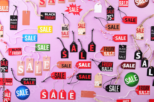 Samples of paper tags with strings and word sale on pink background