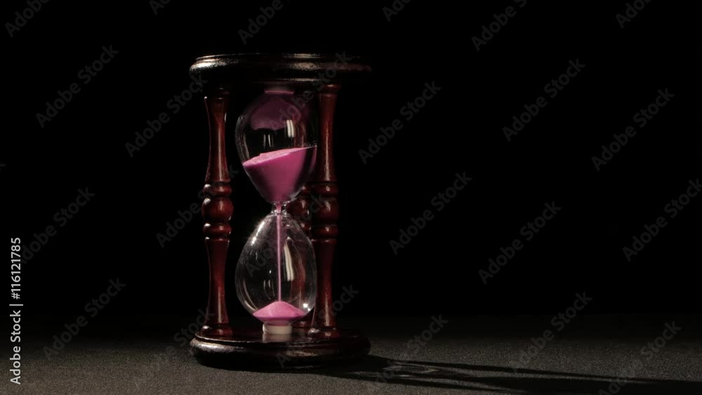 Countdown in the hourglass. Pink sand. Black