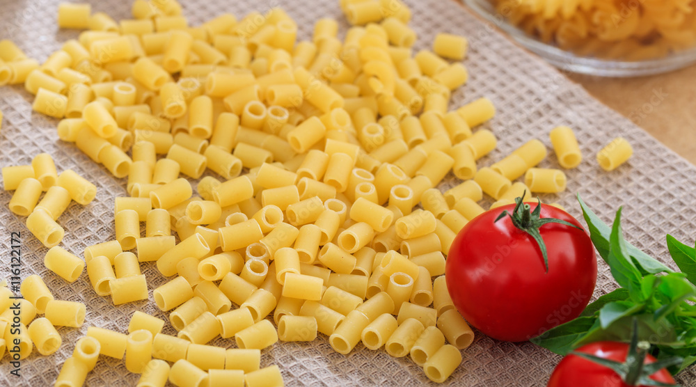 Raw macaroni pasta with tomatoes