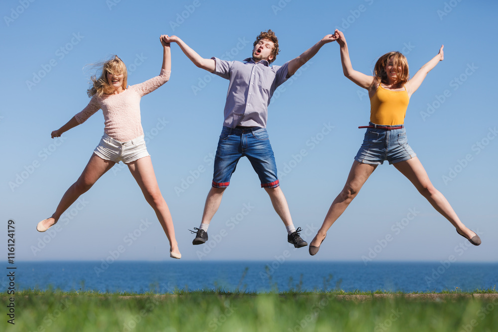 Carefree friends jumping by sea ocean water. Carefree friends jumping by sea ocean water.