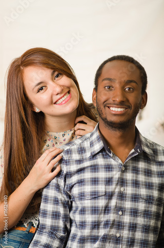 Interracial charming couple wearing casual clothes posing interacting friendly  white studio background