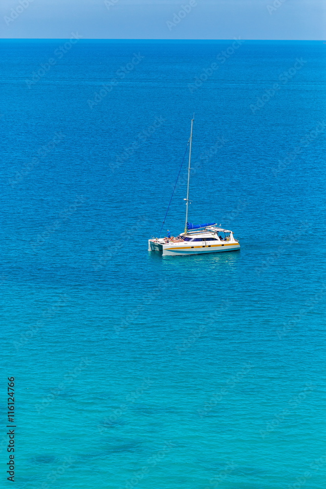 The boat in the azure ocean