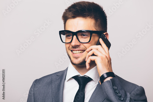 Portrait of young business man talking on phone on white