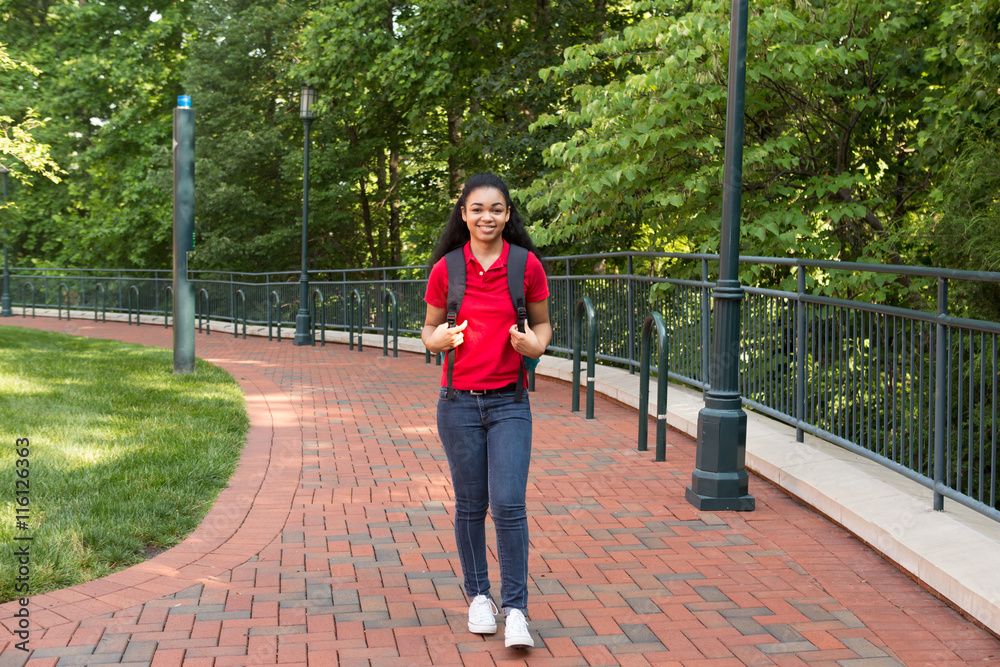 A young african american college student walking on campus