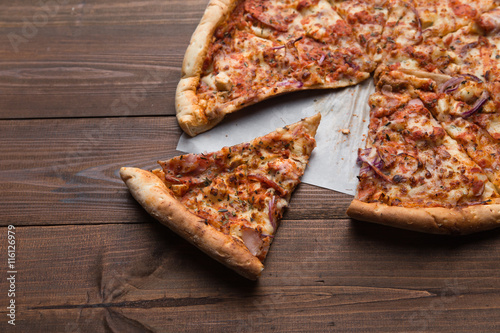 slice of pizza on a wooden background