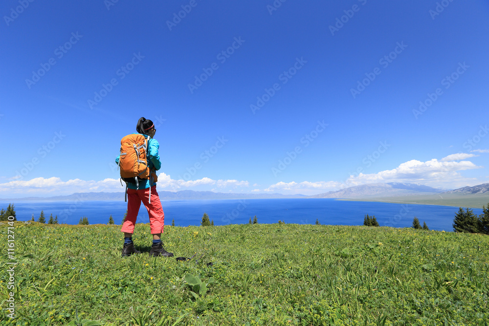 young woman backpacker enjoy the view at mountain peak young woman backpacker enjoy the view at mountain peak