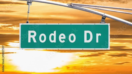 Rodeo Drive Beverly Hills sign with sunset time lapse sky.