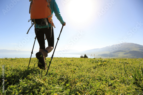  young woman backpacker hiking on beautiful mountain peak trail