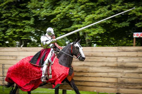 Armored knight on horseback charging in a joust with the lance raised. Jousting is a martial game or hastilude between two horsemen wielding lances with blunted tips, often as part of a tournament