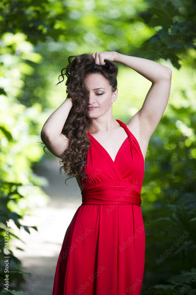 Beautiful young caucasian brunette woman in red dress outdoors Beautiful young caucasian brunette woman in red dress outdoors